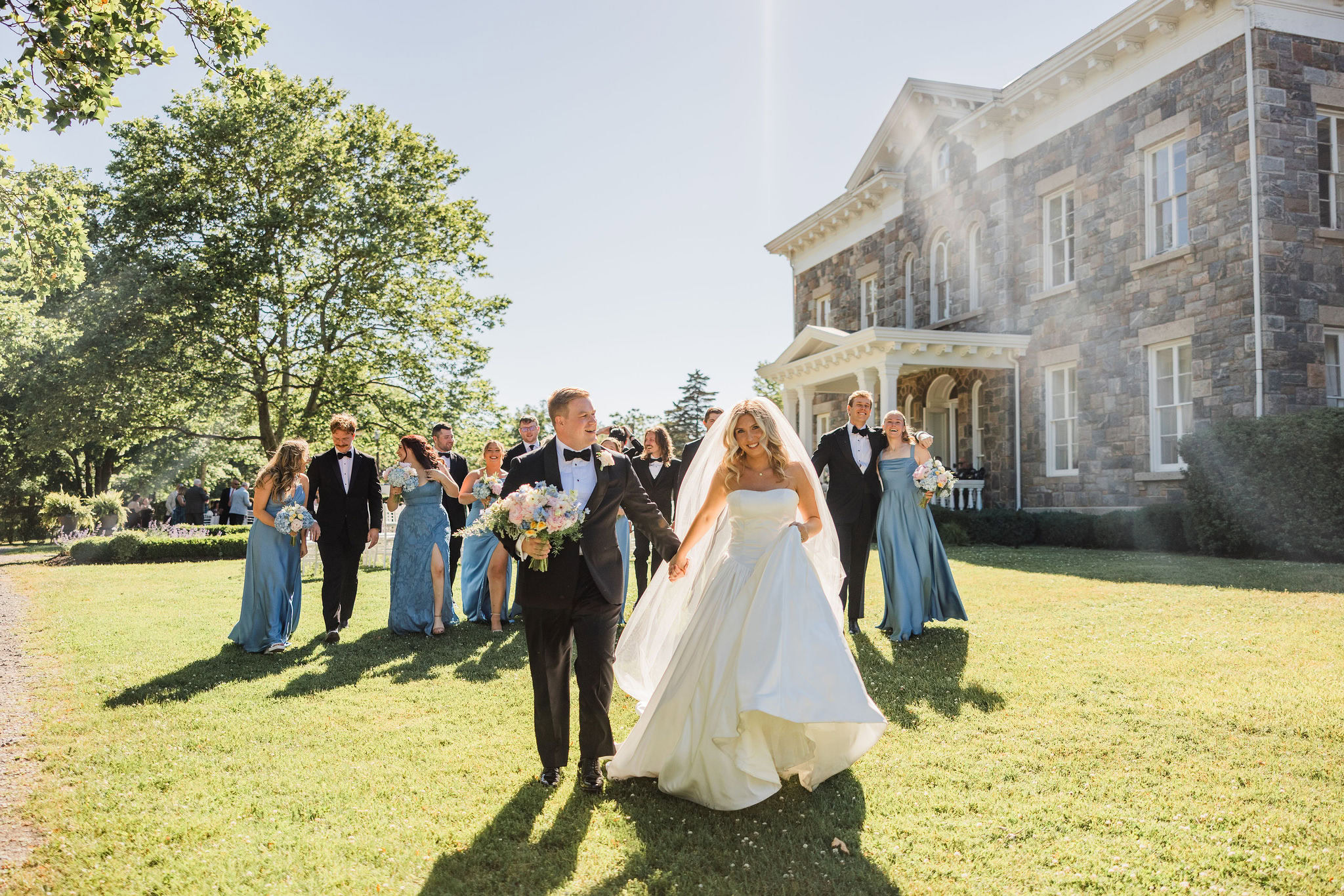 Wedding party walks on the lawn at Brecknock Hall